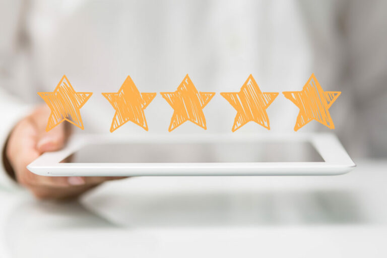 a person is holding a tablet with review stars